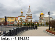 Город Иркутск, Иркутская область, Россия. Вид с набережной реки Ангары на Богоявленский собор. Собор Богоявления Господня построен в первой половине XVIII века. На набережной напротив собора установлен памятник основателям Иркутска. Туристические достопримечательности. Редакционное фото, фотограф Андрей Степанов / Фотобанк Лори