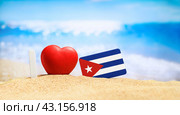 Flag of Cuba on the beach with a red heart. vacation and travel concept. (2023 год). Стоковое фото, фотограф Никита Бурденков / Фотобанк Лори