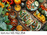 A vibrant spread of fresh tacos, salads, and fruits, ideal for summer picnics and healthy eating. Стоковое AI-изображение, AI-художник Мария Фадеева / Фотобанк Лори
