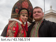 Участники Всероссийского свадебного фестиваля во время шествия от арки главного входа ВДНХ до главной уличной сцены выставки-форума "Россия" в городе Москве, Россия (2024 год). Редакционное фото, фотограф Николай Винокуров / Фотобанк Лори