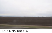 View of a plowed field from the window of a car driving on the road. Стоковое видео, видеограф Александр Прошкин / Фотобанк Лори