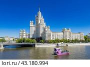 Вид на Высотку на Котельнической набережной, Москва-реку и речной трамвайчик «Рэдиссон Ройал» Radisson Royal (2024 год). Редакционное фото, фотограф Андрей Бойков / Фотобанк Лори