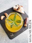 Homemade beef bone and vegetable broth with turmeric seasoning in a glass jar for storage and carrying. Healthy food with collagen and amino acids. Copy space. Стоковое фото, фотограф Глущенко Елена / Фотобанк Лори