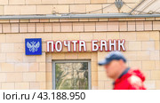 Moscow May 05 2024. Pochta Bank. Sign on building, passers-by walking by blurred in foreground. Редакционное фото, фотограф Скрипачев Антон / Фотобанк Лори
