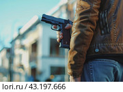 The man walking with a gun in hand on the background of the high school, school shootings concept, school violence. Стоковое AI-изображение, AI-художник Anastacia Gaikova / Фотобанк Лори