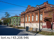 Город Тюмень, Тюменская область, Западная Сибирь, Россия. Красивые старые деревянные дома на улице Дзержинского в историческом центре Тюмени. Благоустроенная пешеходная улица. Справа усадьба Буркова – памятник городского зодчества конца XIX века. (2023 год). Редакционное фото, фотограф Андрей Степанов / Фотобанк Лори