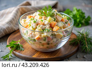Traditional Russian Olivier salad for a feast on a plate on a wooden countertop. generative AI. Стоковое AI-изображение, AI-художник Photojuli / Фотобанк Лори