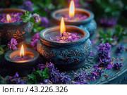 Decorative candles in beautiful carved candlesticks, surrounded by purple flowers and green leaves. Candles burn, creating a warm and cozy light. The candlesticks are made of dark material with delicate carvings that give them an antique look. Purple flowers are scattered around, creating a harmonious and peaceful atmosphere. Стоковое AI-изображение, AI-художник Анна Кривицкая / Фотобанк Лори