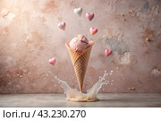 Sweet dessert. The love of ice cream. A heart-shaped ice cream cone with splash, hearts and splashes. The concept of Valentine's Day. Banner, advertisement. Стоковое AI-изображение, AI-художник Photojuli / Фотобанк Лори