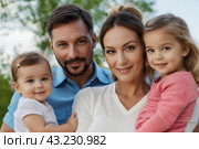 Mom and dad with two small children, close-up. Family portrait, the concept of family relations. The program of state support for families with children. Стоковое AI-изображение, AI-художник Анна Маркина / Фотобанк Лори