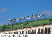"Кто мы, откуда, куда мы идём?". Философская надпись на крыше бывшего приборостроительного завода, Екатеринбург (2018 год). Редакционное фото, фотограф Алексей Иванов / Фотобанк Лори