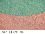 Green and orange rubber coating for playgrounds. EPDM rubber granules. Covering for sports and playgrounds. Rubber mulch for safety and injury prevention with copy space. Стоковое фото, фотограф Darya Komarova / Фотобанк Лори