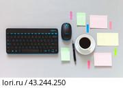 ANGARSK, IRKUTSK REGION, RUSSIA - May 27, 2024: Top view of workplace with Logitech keyboard and mouse, cup of morning coffee and sticky notes for tasks and plans for the day. Copy space, flat lay. Редакционное фото, фотограф Виктория Катьянова / Фотобанк Лори