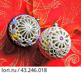 Новогодние шарики, обвязанные крючком - ёлочные украшения на фоне красной праздничной  скатерти. Стоковое фото, фотограф Вера Смолянинова / Фотобанк Лори