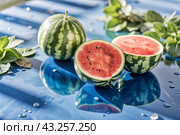 Close-up of fresh watermelon berries. Delicious berries and fruits of bright red color with drops of water. Vegetarianism. Healthy eating. Fresh fruits on the table. Стоковое AI-изображение, AI-художник Photojuli / Фотобанк Лори