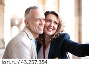 Happy adult couple take a selfie together with smartphone outdoors. Стоковое фото, фотограф Raquel Corcoles Mendez / Фотобанк Лори
