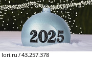 Christmas greeting card with Christmas tree ball and text 2025, garland lights on festive background. Slow motion footage. Стоковое AI-видео, аниматор Ирина Михайличенко / Фотобанк Лори