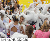 Kamennomostsky, Russia - September 1, 2018: Happy children having fun at a foam party at a holiday town day in an autumn park. Редакционное фото, фотограф Андрей С / Фотобанк Лори