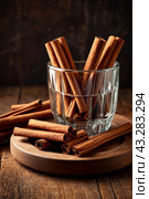 Ceylon cinnamon sticks in glass plate on wooden board, rustic style. Still life natural food of sri lankan cinnamon sticks on table at grey wall. Delicious tasty healthy concept. Copy ad text space. Стоковое AI-изображение, AI-художник Aleksandr Golubev / Фотобанк Лори