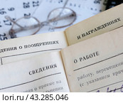 Назначение пенсии. Раскрытая трудовая книжка на фоне листков календаря и очки. Выход на пенсию. Стоковое фото, фотограф Татьяна Т / Фотобанк Лори
