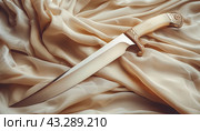 Ceremonial dagger on silk fabric. Стоковое AI-изображение, AI-художник Юрий Поздников / Фотобанк Лори