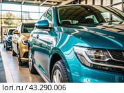A modern car dealership office. The business concept of car sales and rentals. The new car is parked in a modern car dealership. The concept of car leasing and insurance. An electric car. Стоковое AI-изображение, AI-художник Photojuli / Фотобанк Лори