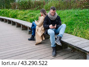 Молодая пара гуляет в лесопарке и пользуются смартфоном. Смартфон в руках. Стоковое фото, фотограф Терехова Марина / Фотобанк Лори