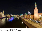 Москва, Россия. Вечерний вид на Москву-реку, Кремлёвскую набережную и башни Московского Кремля. Исторический центр Москвы. Размытый свет от плывущего теплохода на длинной выдержке. Стоковое фото, фотограф Андрей Степанов / Фотобанк Лори