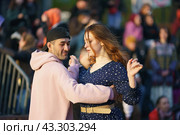 Moscow, Russia - May 9, 2022: Cheerful Dancing couple of young man and woman in public park. Lifestyle theme. Having fun people. People celevrate Victory Day, the win in the Great Patriotic War. Редакционное фото, фотограф YuryKara / Фотобанк Лори