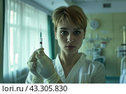 A nurse clutching a syringe tightly in her hands against the background of a hospital room. Стоковое AI-изображение, AI-художник Ярославский Максим / Фотобанк Лори