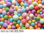The background is made of balls of wool yarn . Needlework, textiles, knitting. Winter season, small business, handmade clothes. Стоковое AI-изображение, AI-художник Photojuli / Фотобанк Лори