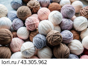 The background is made of balls of wool yarn . Needlework, textiles, knitting. Winter season, small business, handmade clothes. Стоковое AI-изображение, AI-художник Photojuli / Фотобанк Лори
