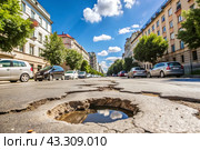 The terrible condition of the roads. A hole in the asphalt on a city street. Road repairs. A city street of poor quality. Стоковое AI-изображение, AI-художник Photojuli / Фотобанк Лори