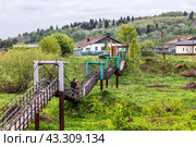 Suspension bridge over the Suenga River. Western Siberia (2024 год). Редакционное фото, фотограф Евгений Мухортов / Фотобанк Лори
