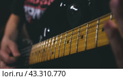 Close-up of a man playing an electric guitar. In the centre of attention is a hand with a plectrum plucking the upper strings. Slow motion of playing the guitar. Стоковое видео, видеограф Воловодов Владимир / Фотобанк Лори