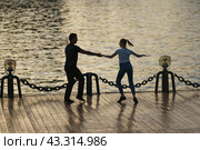 Moscow, Russia - May18, 2021: Cute heterosexual couple of man and woman dances in public park. Beautiful pair. Leisure concept. Healthy lifestyle theme. Deep dive in dance. Редакционное фото, фотограф YuryKara / Фотобанк Лори
