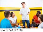 Male student discussing with groupmates sitting in circle in auditorium during classes. Стоковое фото, фотограф Яков Филимонов / Фотобанк Лори
