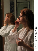 Rome Beautiful young woman in bathrobe putting on makeup in the bathroom. Стоковое фото, фотограф Константин Сергеевич Синявин / Фотобанк Лори