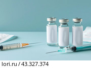 Syringe and glass vial on blue background table. Medical Vials group, needles, ampoules, bottle with medicines or vaccine. Disease treatment. Creative Banner. Anti-aging beauty injections. Vaccination. Стоковое AI-изображение, AI-художник Марина Демидюк / Фотобанк Лори
