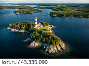 Aerial view landscape of archipelago of islands with lighthouse in Gulf of Finland, skyline at blue sky background. Amazing natural wild scenery view of Scandinavian nature. Copy ad text space. Стоковое AI-изображение, AI-художник Aleksandr Golubev / Фотобанк Лори