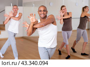 Latin american dancer practicing synchronous choreography with group. Стоковое фото, фотограф Яков Филимонов / Фотобанк Лори
