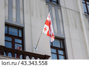 A flag of Georgia with red, white, and blue colors and a cross design on it. Стоковое фото, фотограф Аксенова Вера / Фотобанк Лори
