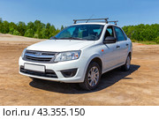 Russian car Lada Granta on summer sunny road (2024 год). Редакционное фото, фотограф Евгений Ткачёв / Фотобанк Лори