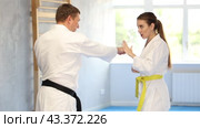 Active young girl and middle-aged man practicing kicks and blocks in pair during karate courses. Стоковое видео, видеограф Яков Филимонов / Фотобанк Лори