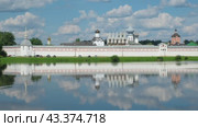 Тихвинский Успенский монастырь отражается в летних водах озера Таборы. Небо в облаках. Тихвин, Ленинградская область, Россия (2024 год). Стоковое видео, видеограф Ольга Визави / Фотобанк Лори