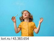Ребенок в желтой футболке с сигаретой на голубом фоне. Стоковое AI-изображение, AI-художник Щеголева Ольга / Фотобанк Лори