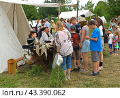 Historical reconstruction in beautiful historical and authentic costumes at festival Times and Epochs in Moscow. Visitors at military camp (2024 год). Редакционное фото, фотограф Валерия Попова / Фотобанк Лори