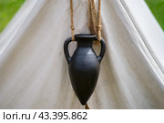 A clay jug hangs at the entrance to the tent of an ancient Roman warrior. Стоковое фото, фотограф Андрей Журавлев / Фотобанк Лори