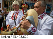 Артисты в традиционных народных костюмах из республики Марий Эл играют на национальных музыкальных инструментах на территории ВДНХ в городе Москве, Россия (2024 год). Редакционное фото, фотограф Николай Винокуров / Фотобанк Лори