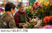A flower seller helps a customer choose a bouquet. Стоковое AI-изображение, AI-художник Ярославский Максим / Фотобанк Лори